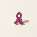 Pink breast cancer awareness ribbon pin on a warm white background